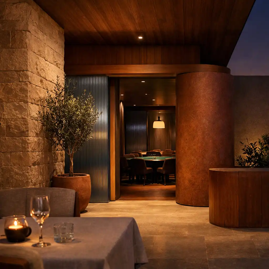 A sandstone and timber threshold leading from a softly lit dining area towards Jogo Dourado’s intimate Card Lounge.